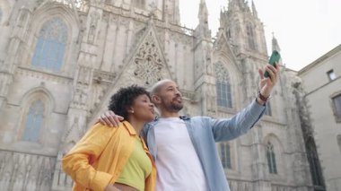 Genç turistler, ikonik barselona katedralinin önünde selfie çekerken hatırlanmaya değer tatil anlarını yakalıyorlar güneşli bir günün tadını çıkarıyor ve seyahat deneyimlerini paylaşıyorlar.