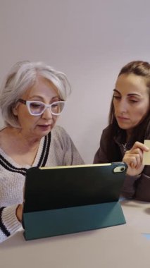 Son sınıf öğrencisi kız kardeşleriyle online alışveriş yapmayı öğreniyor, tabletten kredi kartı kullanıyor.