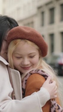 Kentsel caddede samimi kucaklaşmayı paylaşan genç kadınlar, duygusal destek ve gerçek bağlantılarını ifade ediyorlar.