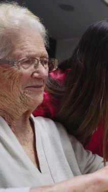 Mutlu, yaşlı bir kadın bakıcısıyla vakit geçirmekten zevk alıyor. Yavaş çekimde iç açıcı bir bağ ve sevinç anı yaşıyor.