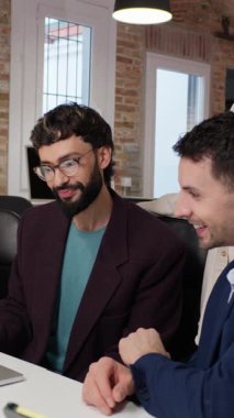 Çeşitli başlangıç ekibi üyeleri, proje detaylarını yavaş çekimde tartışarak, takım çalışmasını ve yenilikleri teşvik ederek, iş birliği yaparlar.