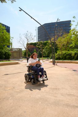 Engelli mutlu kadın şehir parkında sosyal medyada geziniyor.