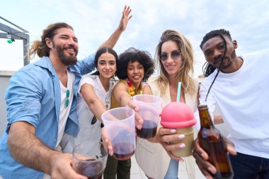 Çeşitli arkadaş grupları kadehlerini kaldırarak kadehlerini kaldırıyor. Çatıdaki partiden ve içkilerden keyif alıyorlar.