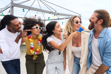 Beş neşeli arkadaş canlı bir çatı partisinde eğleniyor, karaoke söylüyor ve birlikte parıldayan ışıklar altında sevinçle kutluyorlar.