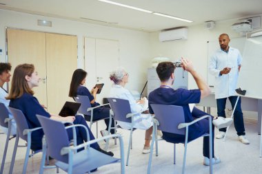 Tıp konferansına katılan doktorlar ve hemşireler, sağlık bilgisinin iyileştirilmesi ve çağdaş hastane ortamında takım çalışmasının teşvik edilmesi