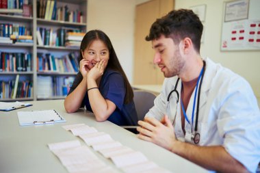 Hastane ortamında ekip çalışması yapan, hasta verilerini ve tedavi planlarını analiz eden tıp uzmanları