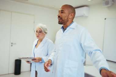 Bir hastane ortamında işbirliği yapan ve uzmanlığı paylaşan tıp uzmanları, takım çalışmasının ve sağlık alanındaki mükemmelliğin altını çiziyor