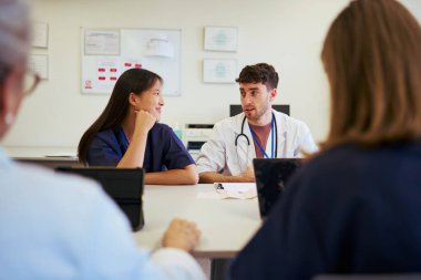 Doktor ve hemşireler ortak bir tartışmaya giriştiler, hasta bakımını iyileştirmek için uzmanlıklarını ve görüşlerini paylaştılar.