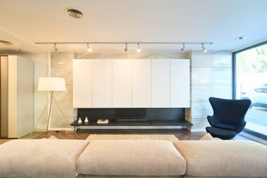 Modern ve şık oturma odası iç tasarımı bir mobilya galerisinde sergileniyor, modern mobilyalar, ışıklandırma ve minimalist bir estetik içeriyor.