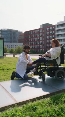 Tekerlekli sandalyedeki hastalara sağlık hizmetlerine erişim ve hareket kabiliyetini vurgulayan tıbbi uzman destek ve bakım sunar.