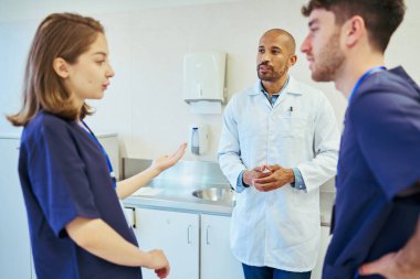 Doktorlar ve hemşireler işbirliği yapıyor, uzmanlıklarını paylaşıyor ve modern hastane ortamında hasta bakımını koordine ediyorlar.