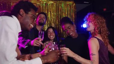 Mutlu arkadaşlar yeni yıl arifesini kutluyor, şenlikli bir atmosferde şampanya kadehleriyle kadeh kaldırıyor, yavaş çekimde çekiliyor.