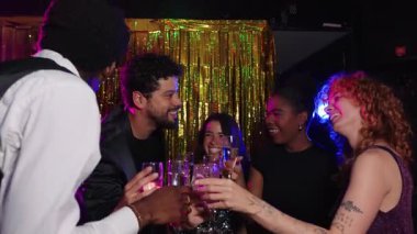 Neşeli arkadaşlar yeni yıl arifesini kutluyor, şenlikli bir atmosferde şampanya kadehleriyle kadeh kaldırıyor, yavaş çekimde çekiliyor.