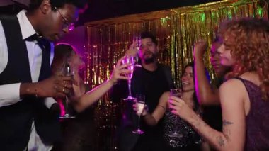 Yeni yıl arifesini kutlayan şık arkadaşlar, şenlikli bir atmosferde şampanya kadehleri kaldırıyor, yavaş çekimde çekiliyor.