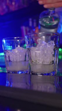 Barmen rom koyuyor, buz ekliyor, nane ekliyor ve bir gece kulübünde canlandırıcı mojito kokteyli hazırlıyor.