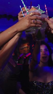 Gece hayatını seven genç kadınlar, canlı bir barda kutlama yapmak için kadeh kaldırıyorlar.