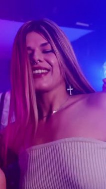 Genç bir transseksüel kadının gece hayatının tadını çıkarırken, canlı bir gece kulübünde arkadaşlarıyla dans ederken yavaş çekim montajı.