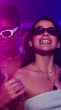 Enerjik bayan arkadaşlar dans ediyor, coşkulu bir gece kulübünde tutkuyla şarkı söylüyor, hafta sonu gecesini neşeli, kaygısız bir hareketle kutluyorlar.