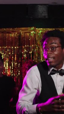 Yeni yıl partisinde kokteyl eşliğinde dans eden enerjik garson neşeli hareketler yakalıyor ve yavaş çekimde kutlama yapıyor.