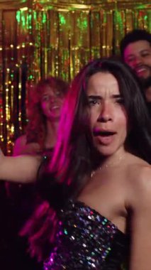 Yavaş çekimde dans eden ve arkadaşlarıyla eğlenen genç bir kadının videosu.