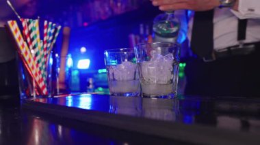 Yetenekli barmen mojito kokteylini dikkatlice karıştırıyor. Canlı bir gece kulübü ortamında taze malzemelerle profesyonelliği birleştiriyor.