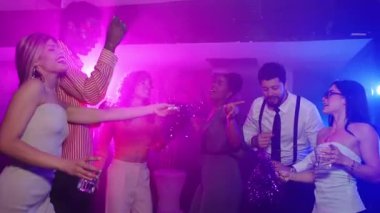 Bir gece kulübünde dans eden ve içen çok ırklı arkadaş grubu, ağır çekimde müzik ve atmosferin tadını çıkarıyor.