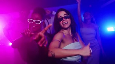 Bulaşıcı bir neşeyle dans eden bayan arkadaşlar, genç arkadaşlığın dinamik yavaş çekim kutlamasıyla enerjik bir gece kulübü enerjisi yaşıyorlar.