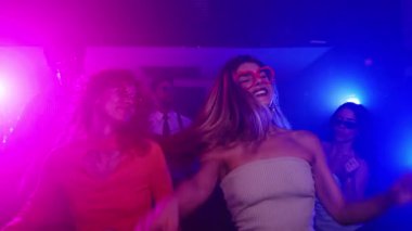 Enerjik kadınların dans ettiği canlı bir gece kulübü sahnesi, neşeli hareketler ve ağır çekimde bulaşıcı ritimler yakalıyor.
