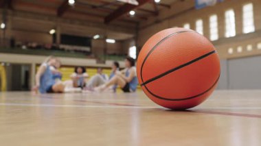 Tahta kortta dinlenen basketbol, molada iyileşen bulanık sporcular, takımları bir an için spor faaliyetlerinde durdurma