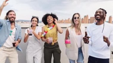 Mutlu arkadaşlar çatıdaki bir partide dans edip içiyorlar, yaz havasının ve şehrin tadını çıkarıyorlar.