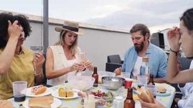 Sıcak yaz akşamları şehrin çatısında ızgara yapan ve sosyalleşen bir grup genç arkadaş lezzetli yemekleri paylaşıyor ve birlikte gülüyorlar.