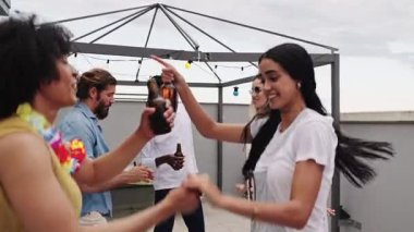 Çeşitli genç arkadaşlar dans ediyor, gülüyor ve içkilerini paylaşıyor. Şehrin arka planıyla canlı çatı kutlamalarının tadını çıkarıyorlar.