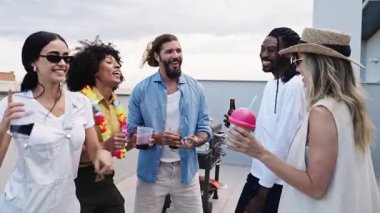 Neşeli arkadaşlar çatıda içki içip sohbet ederek arkadaşlığımızı ve iyi zamanlarımızı kutluyorlar.