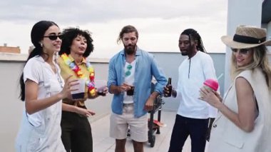 Çeşitli genç yetişkinlerden oluşan bir grup canlı çatı kutlamaları, dans ve içkileri paylaşıyorlar. Altın gece ışığı altında, arka planda şehrin silüeti var.