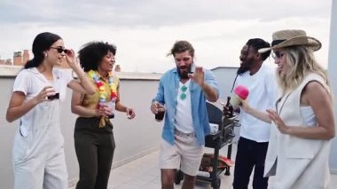 Neşeli arkadaşlar dans ediyor ve çatıdaki bir partide içki içiyor, arkadaşlığımızı ve birlikte geçirdiğimiz güzel zamanları kutluyorlar.