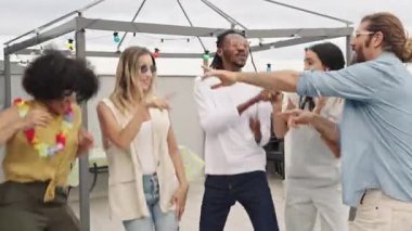 Çok kültürlü bir grup genç arkadaş enerjik bir şekilde şarkı söylüyor ve yaz boyunca canlı şehir çatılarında karaoke gösterisi yapıyorlar.