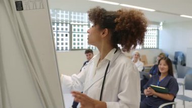 Ekip brifingi sırasında tıbbi profesyonel bilgi paylaşımı, hastane konferans odasında iş arkadaşlarıyla sağlık çizelgesini analiz etmek,