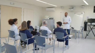 Sağlık uzmanları bir toplantı için toplanıyor ve hasta bakımı stratejileri hakkında tartışıyorlar.