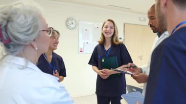 Doctors and nurses review patient data, exchanging insights and expertise in a hospital setting