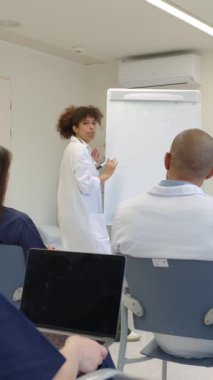 Hastane toplantı odasında yapılan sunum sırasında meslektaşlarına sağlık stratejisini açıklayan kadın doktor, ağır çekim