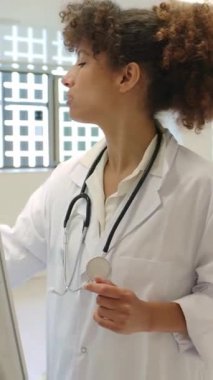 Ağır çekim sağlık dersi sırasında beyaz tahtaya yazı yazarken tanısal kavramları açıklayan profesyonel bir kadın, profesyonel eğitim ortamında bilimsel bilgileri paylaşıyor.