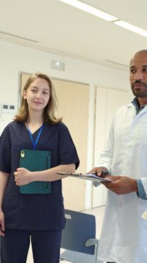 Doktor hemşirelere bir şey anlatıyor. Hastane koridorundaki bir panoya işaret ediyor.