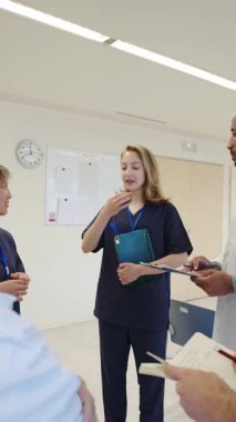 Hastane personeli ağır çekimde hasta bakımını tartışıyor, takım çalışmasını ve sağlık hizmetlerindeki iletişimi vurguluyor