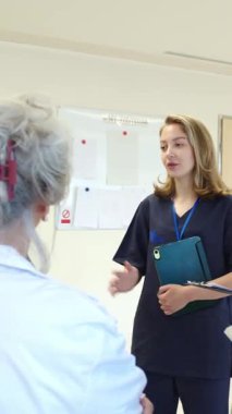 Hastane personeli hastaların tıbbi kayıtlarını tartışıyor, profesyonel ve güven verici bir atmosfer yaratıyor.