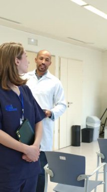 Doktor elinde bir panoyla hemşireye bir şey anlatıyor. Hastanede ağır çekim.