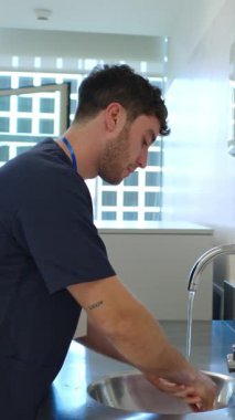 Tıbbi uzmanlar el hijyenini titizlikle uyguluyor, odaklanmış teknik ve hassasiyetle hastane lavabosunda ellerini dikkatlice yıkıyor, temizliği ve enfeksiyonu önlemeyi ön plana çıkarıyor.