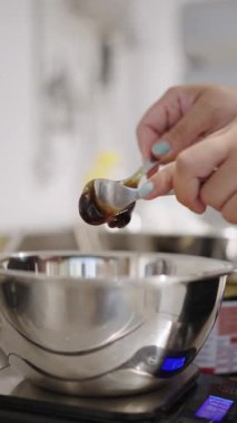 Pasta şefi mutfak terazisine koyu mısır şurubu koyuyor.