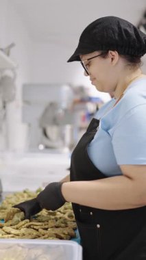 Pasta şefleri profesyonel bir mutfakta makarnalı kurabiyeler hazırlıyorlar.