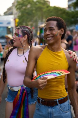 Gurur festivalinde yürüyen ve el ele tutuşan genç çift, lgbtq hakları ve cemaati kutluyor.