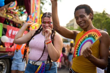 İki genç dans ediyor ve bir gurur festivalinde eğleniyor, lgbtq hakları için kimliklerini ve desteklerini ifade ediyorlar.